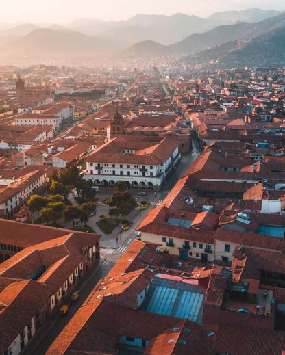 Vue aérienne du centre historique de Cusco avec ses toits rouges et les montagnes andines en arrière-plan au Pérou.