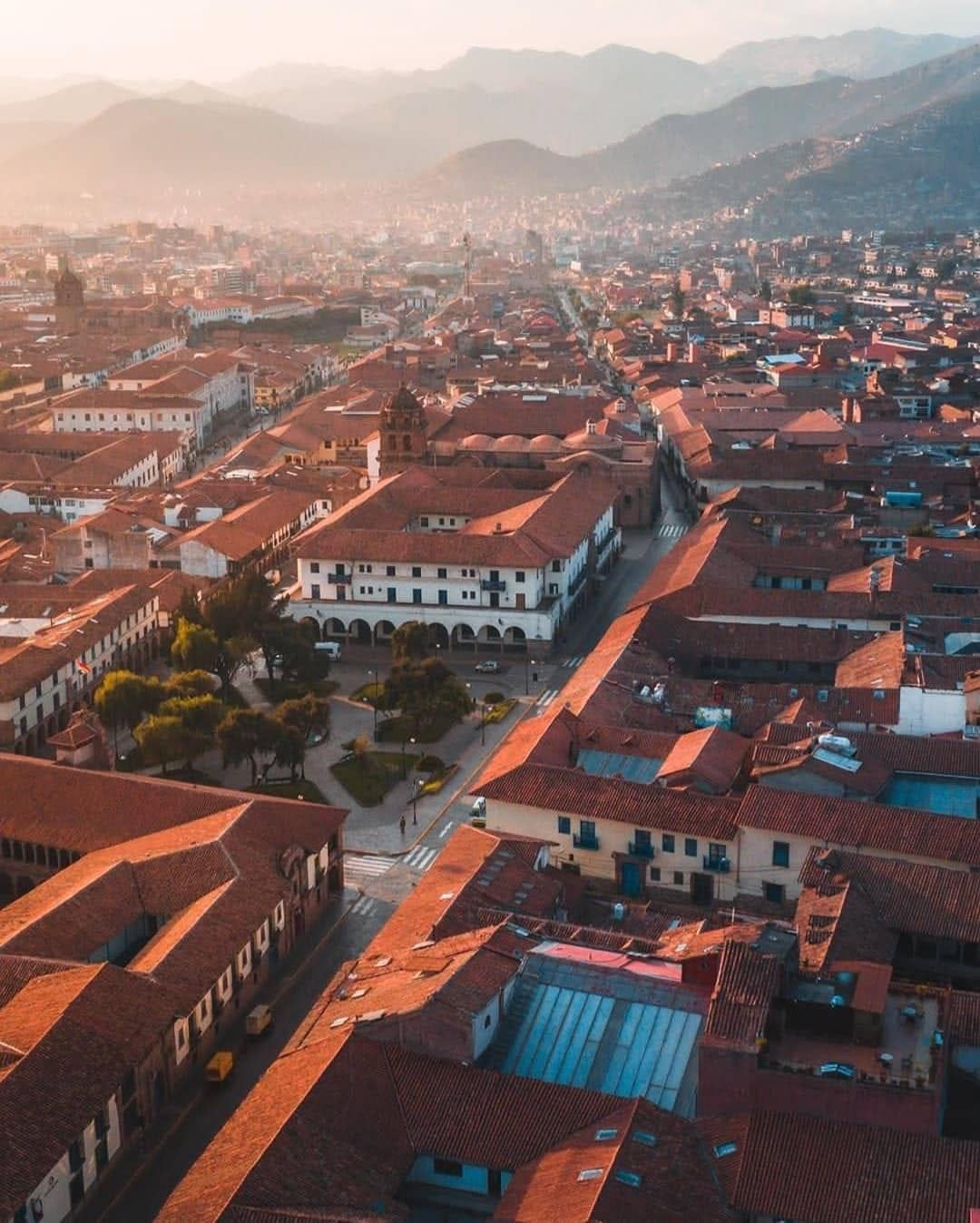 Vue aérienne du centre historique de Cusco avec ses toits rouges et les montagnes des Andes en arrière-plan au Pérou.