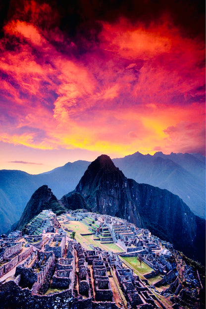 Vue du Machu Picchu dans les Andes du Pérou au coucher du soleil avec un ciel rouge spectaculaire.