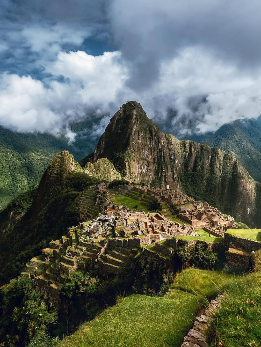 Vue panoramique du Machu Picchu entouré des montagnes verdoyantes des Andes au Pérou.