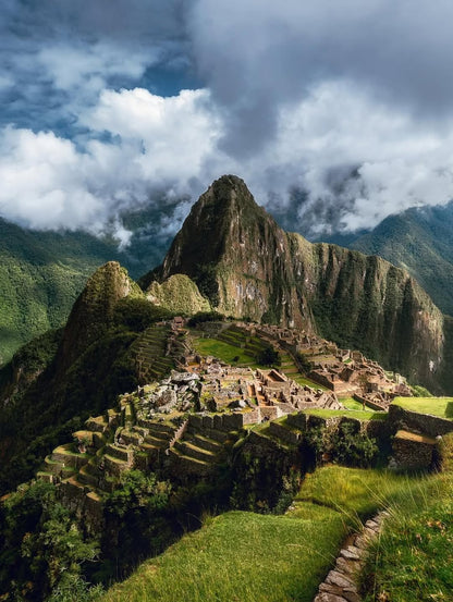 Vue panoramique du Machu Picchu entouré des montagnes verdoyantes des Andes au Pérou.