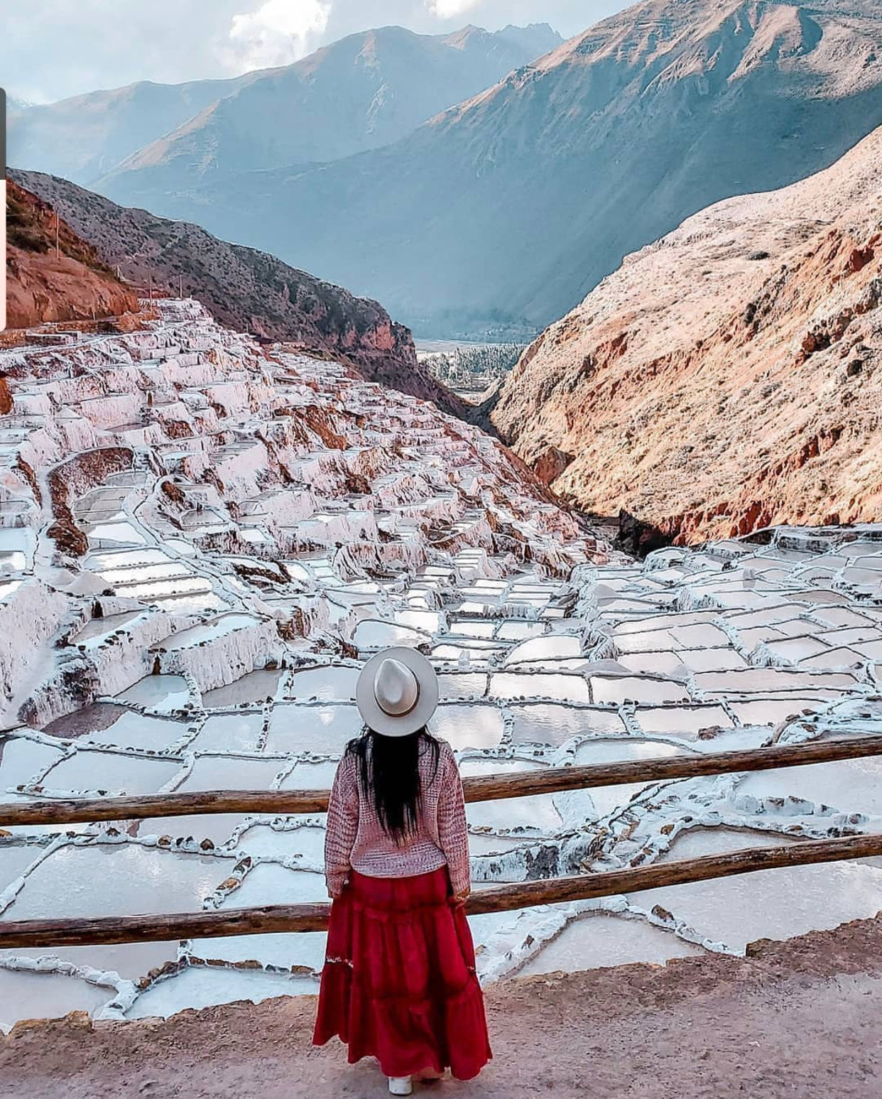 Vue des marais salants de Maras dans la vallée sacrée près de Cusco au Pérou avec une visiteuse observant les bassins de sel.